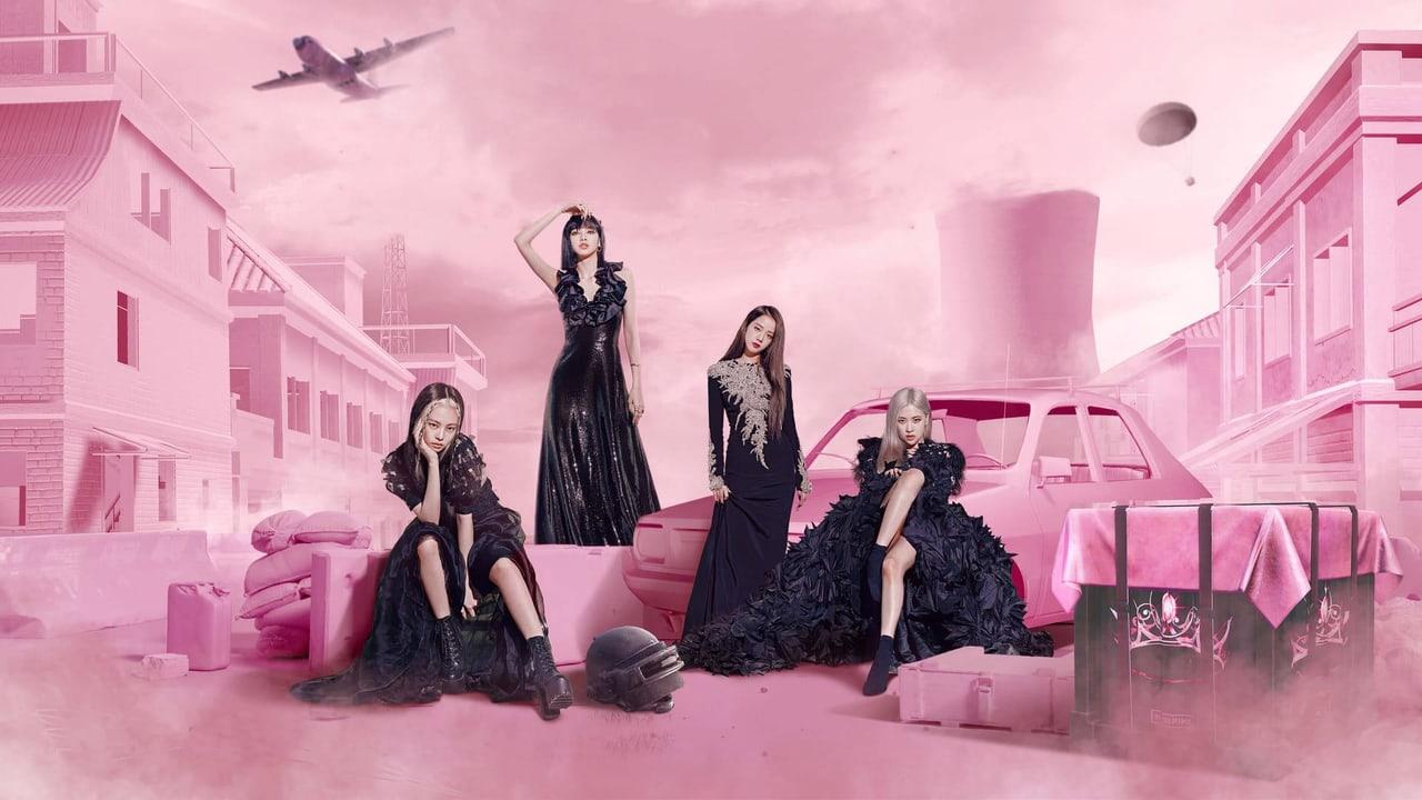 The four members pose among pink buildings, a car and stacked props beneath a pastel sky.