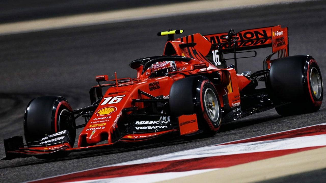 Leclerc's historical number 16 Ferrari turns across red and white curbing. The front wing and rear wheel reach the side strips beside the dark track surface.