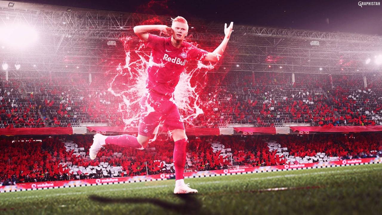 A historic Salzburg kit appears in a red fan composition of Haaland leaping above a stadium crowd. Floodlights and red stands fill the edges. Source: tu_amgel-caido-666 on Wallpapers.com. Original artist not identified by the page.