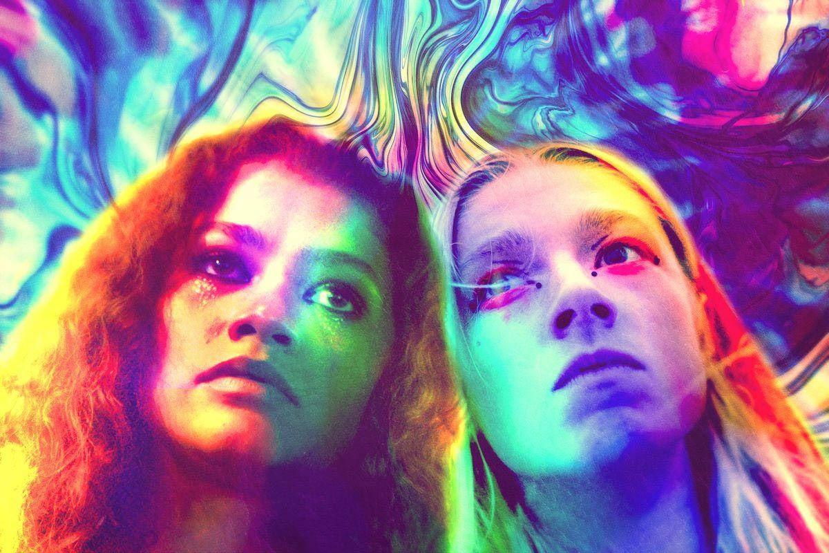 Rue and Jules look upward through swirls of violet, green and yellow light. Flowing color and hair carry the psychedelic texture into the outer strips.