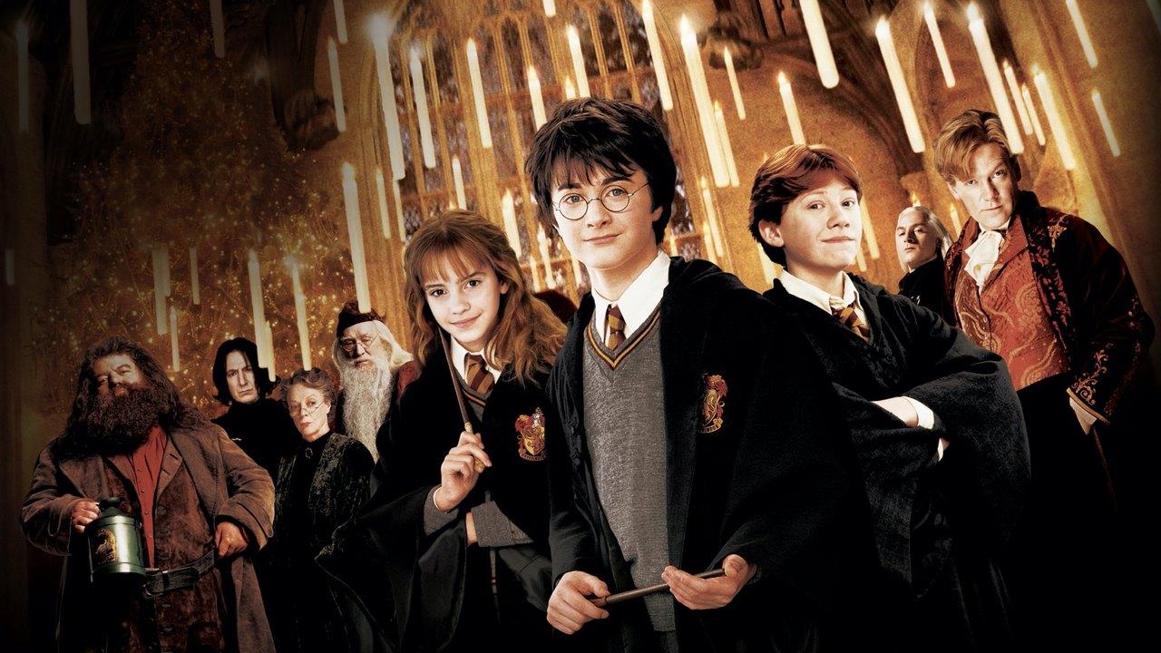 The Hogwarts ensemble gathers in the Great Hall beneath floating candles and warm golden light.
