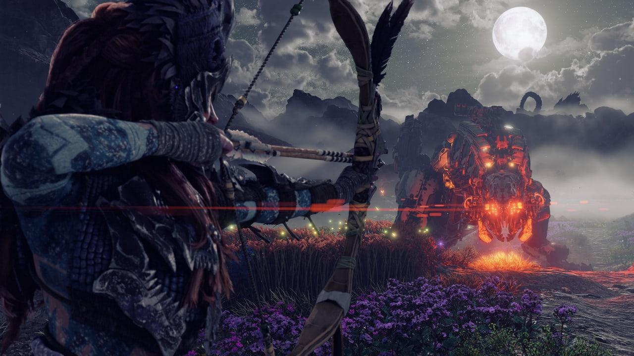 Aloy aims her bow toward a blazing machine beneath a moonlit sky. Armor, purple flowers and a winding mountain path border the central action.