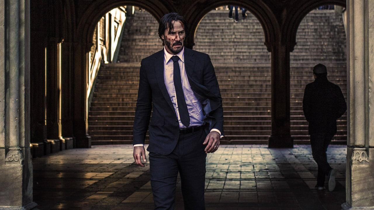 John Wick walks beneath stone arches beside a broad staircase. Columns and a second walking figure preserve the architecture in both outer strips.