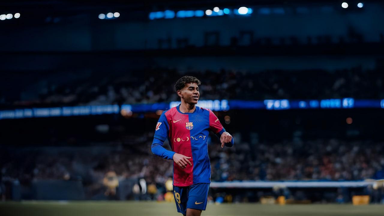 Lamine Yamal stands in a Barcelona shirt on a football pitch beneath blue-lit stadium tiers.
