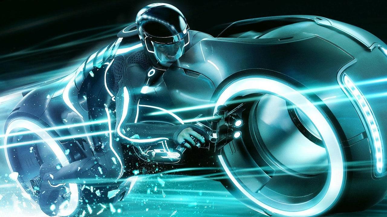 A rider leans into a luminous cyan lightcycle amid bright trails and shards. The wheels and streaming lines span the width of the image. Source: swiftshawn on Wallpapers.com. Original artist not identified by the page.