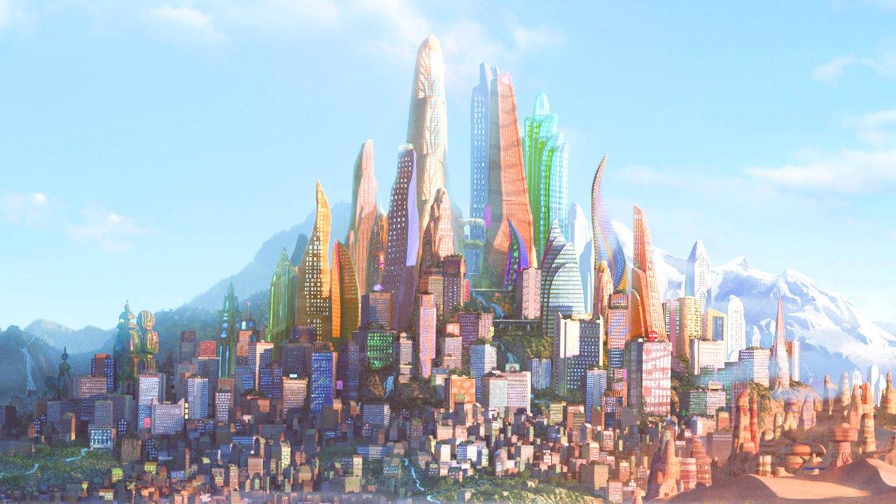 Colorful towers and dense neighborhoods rise toward snowy mountains beneath a clear blue sky.