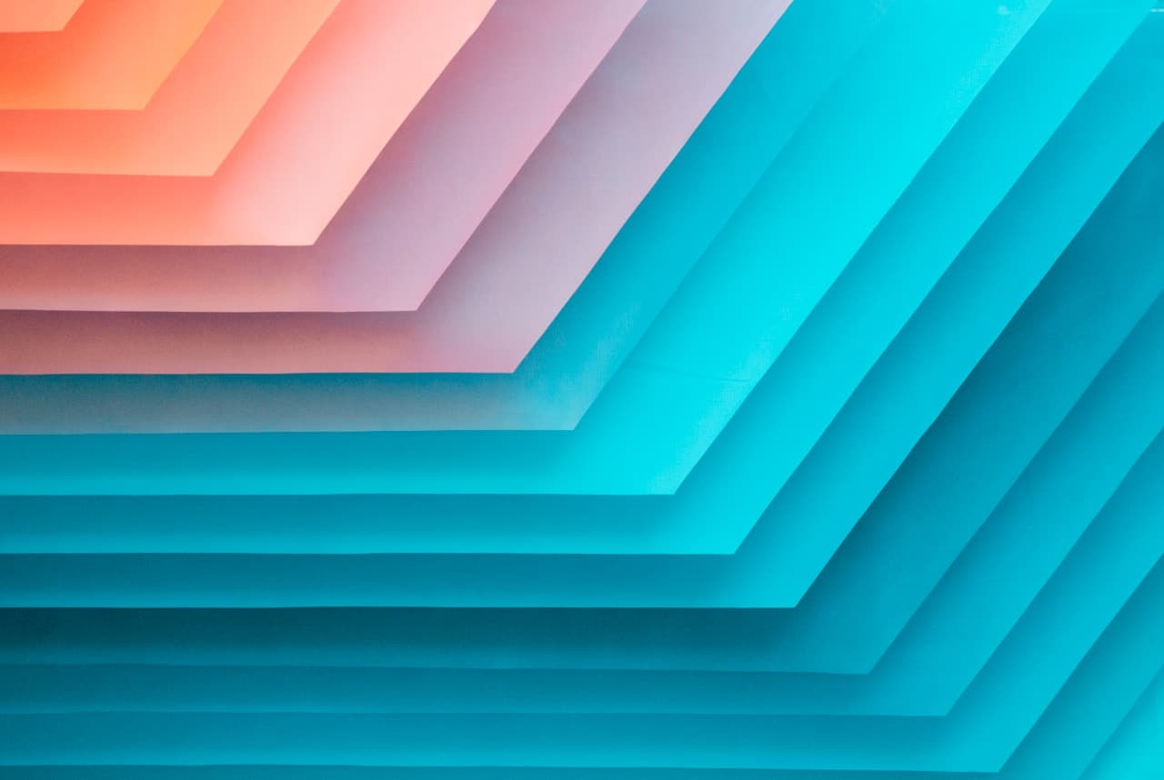 Abstract digital artwork of stepped, layered shapes arranged diagonally like stacked paper cutouts. The right side is dominated by teal and aqua layers, while the upper-left corner fades through peach, coral, and lavender tones. Soft gradients and gentle shadows create a subtle 3D effect, as if the layers are offset in depth. The composition is clean and geometric, with strong diagonal direction and smooth negative space. Lighting feels like a soft studio glow. Mood is modern, airy, and optimistic.