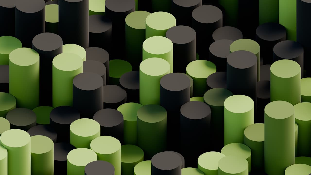 Top-down view of a dense field of cylindrical columns in alternating shades of green and matte black. The cylinders cluster tightly, creating a rhythmic pattern like an abstract cityscape. Soft directional lighting adds gentle highlights to the rounded tops and subtle shadows between forms, giving depth without harsh contrast. The palette stays limited to greens and dark neutrals, making the design feel modern and graphic. The scene is clearly computer-generated or highly stylized. Mood is orderly, calm, and tech-inspired.