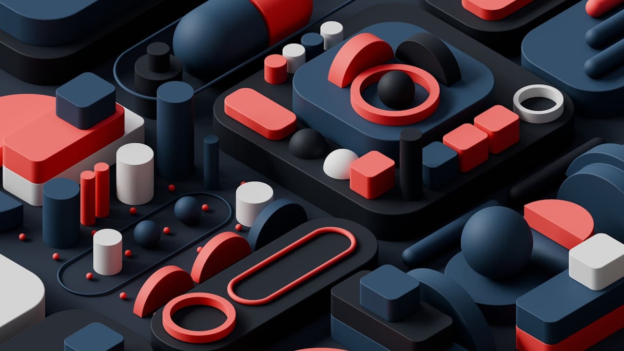 Detailed 3D abstract scene resembling a tabletop of miniature components—blocks, cylinders, rings, and rounded platforms—arranged in a dense grid. Most elements are dark navy and charcoal, while bold red accents and a few white pieces punctuate the layout. Soft studio lighting creates clean highlights on edges and gentle shadows in recesses, giving the scene a refined product-render look. The composition is angled, adding depth and leading lines, with no single focal object—just a rich geometric landscape. Mood is modern, technical, and slightly futuristic.