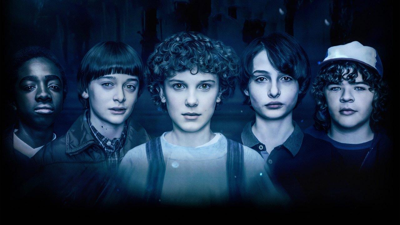 Hawkins cast in electric blue A wide row of five blue-lit Hawkins portraits stretches across a shadowed background.